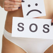 Señal de SOS delante de la pelvis de una mujer