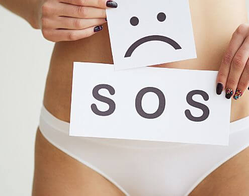 Señal de SOS delante de la pelvis de una mujer