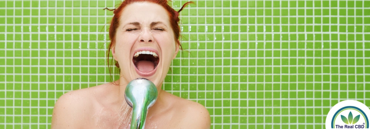 Mujer cantando en la alcachofa de una ducha verde