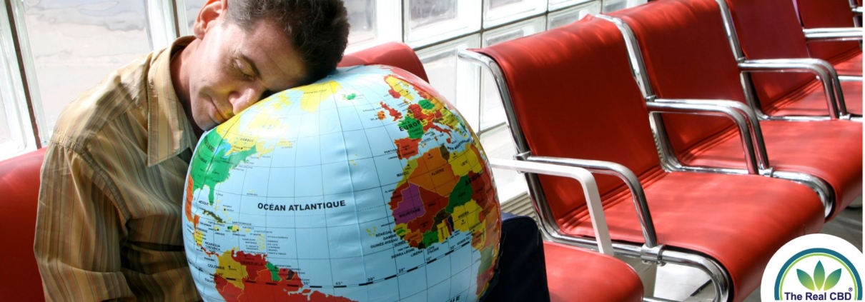 Hombre en el aeropuerto durmiendo con la cabeza sobre un globo terráqueo