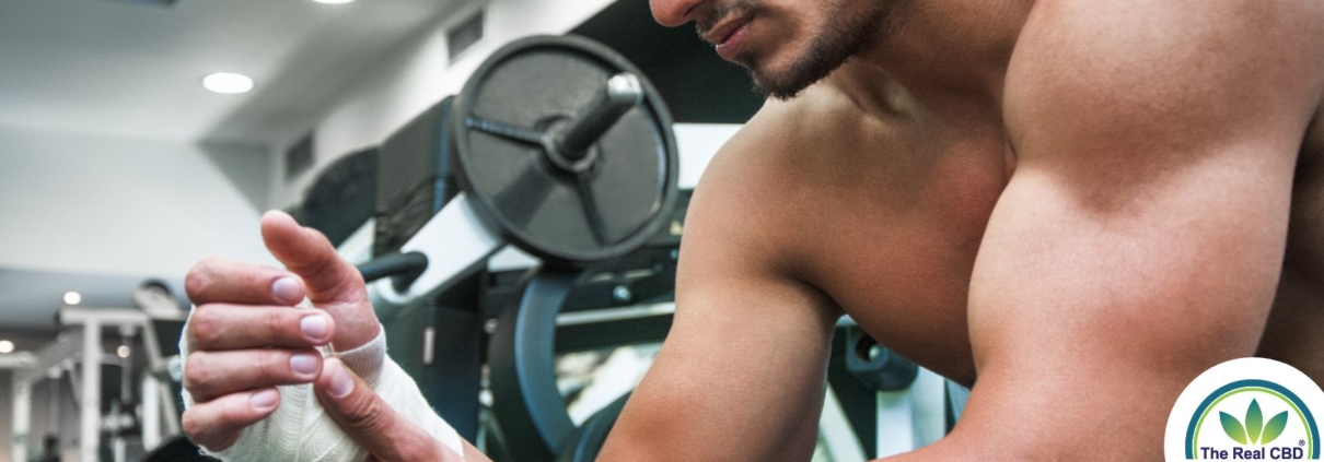 Hombre musculoso en el gimnasio con la muñeca vendada