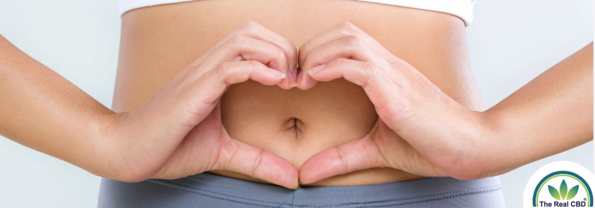 Mujer haciendo forma de corazón con las manos delante de su vientre