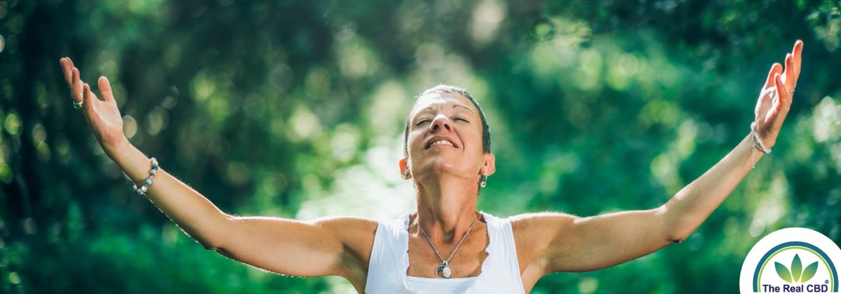 Mujer en el bosque con los brazos abiertos