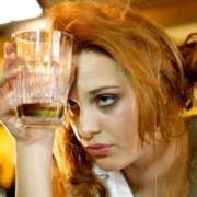 Mujer con resaca sosteniendo un vaso de bebida