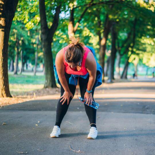 Mujeres agachadas por el cansancio en una pista de atletismo