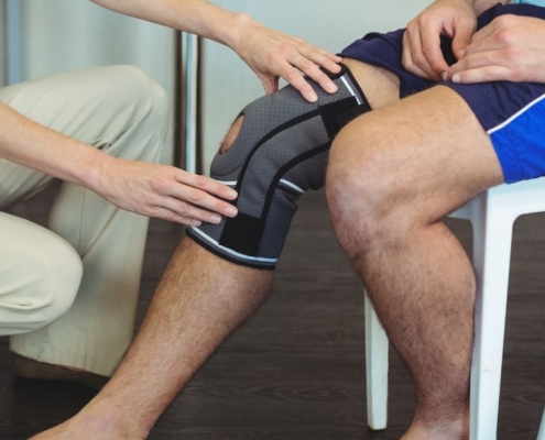 Un cuidador ayuda a un paciente con una lesión de rodilla