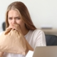Mujer respirando en una bolsa de papel marrón