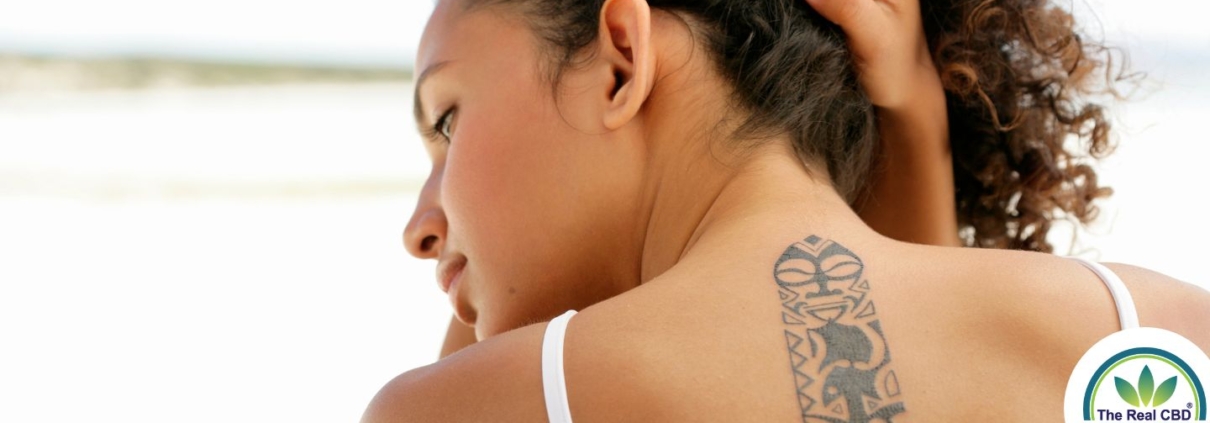 Mujer que se levanta el pelo para mostrar un tatuaje
