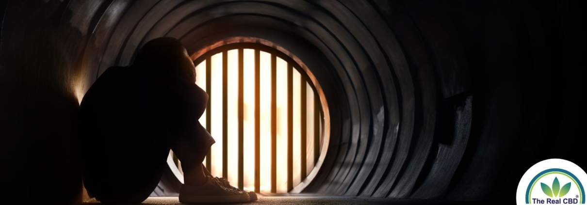 Niño sentado en un túnel con la cabeza apoyada en las rodillas