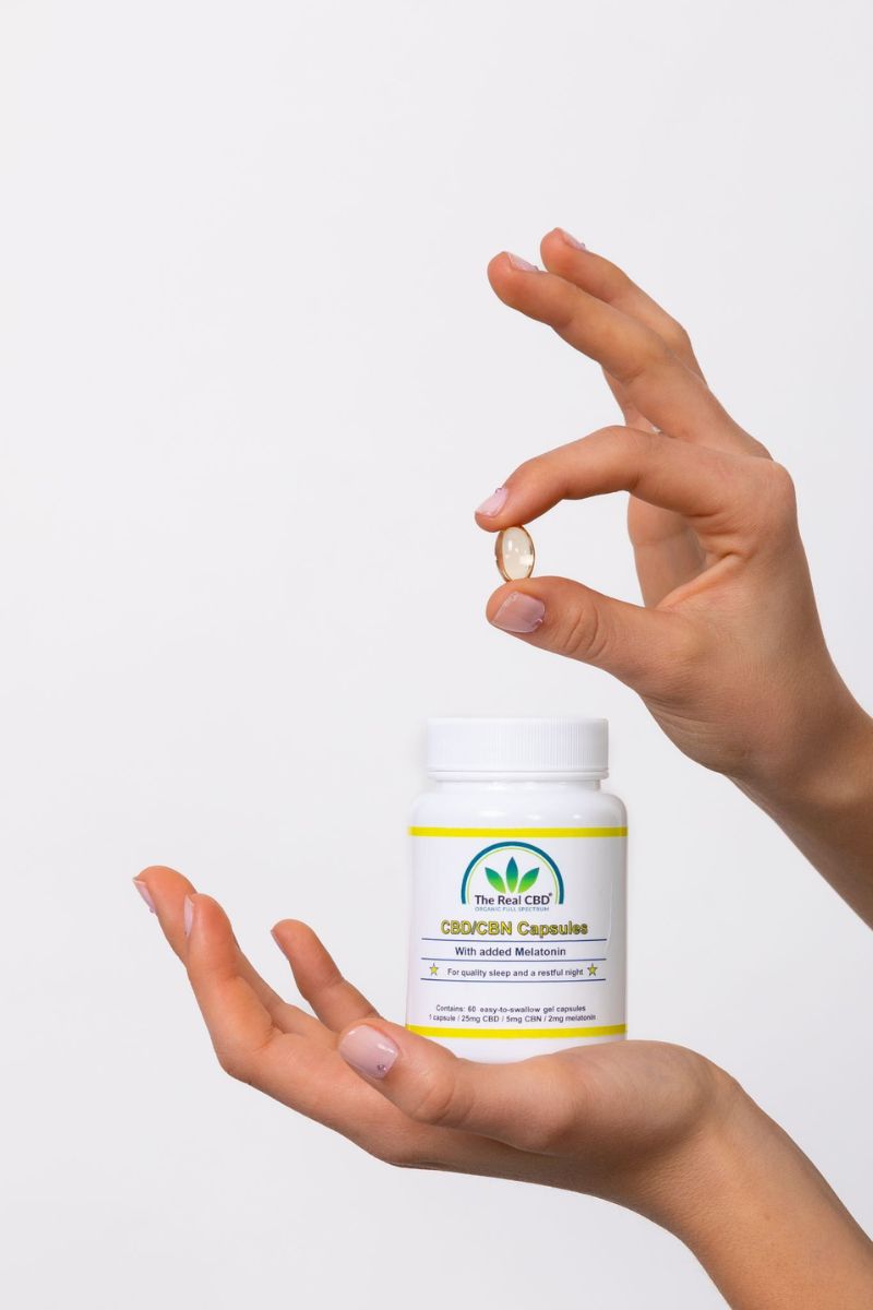 Manos mostrando la cápsula de gel de CBD - The Real CBD Marca