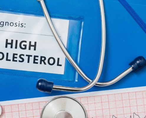 Informe médico sobre colesterol alto, pastillas y estetoscopio