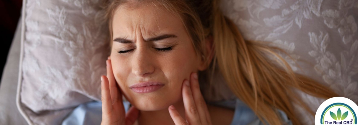 Mujer sujetándose las mandíbulas por el dolor