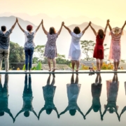 Una fila de mujeres felices al borde de una piscina en una puesta de sol