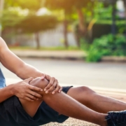 The-Real-CBD-Blog-CBD para espasmos musculares Corredor en el suelo sujetándose la rodilla por el dolor