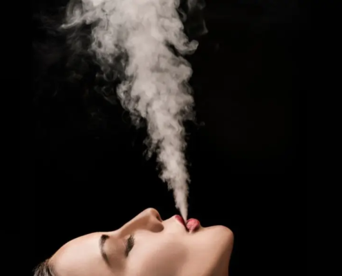 Mano sujetando un porro. Mujer fumando. Mano sosteniendo aceite de CBD