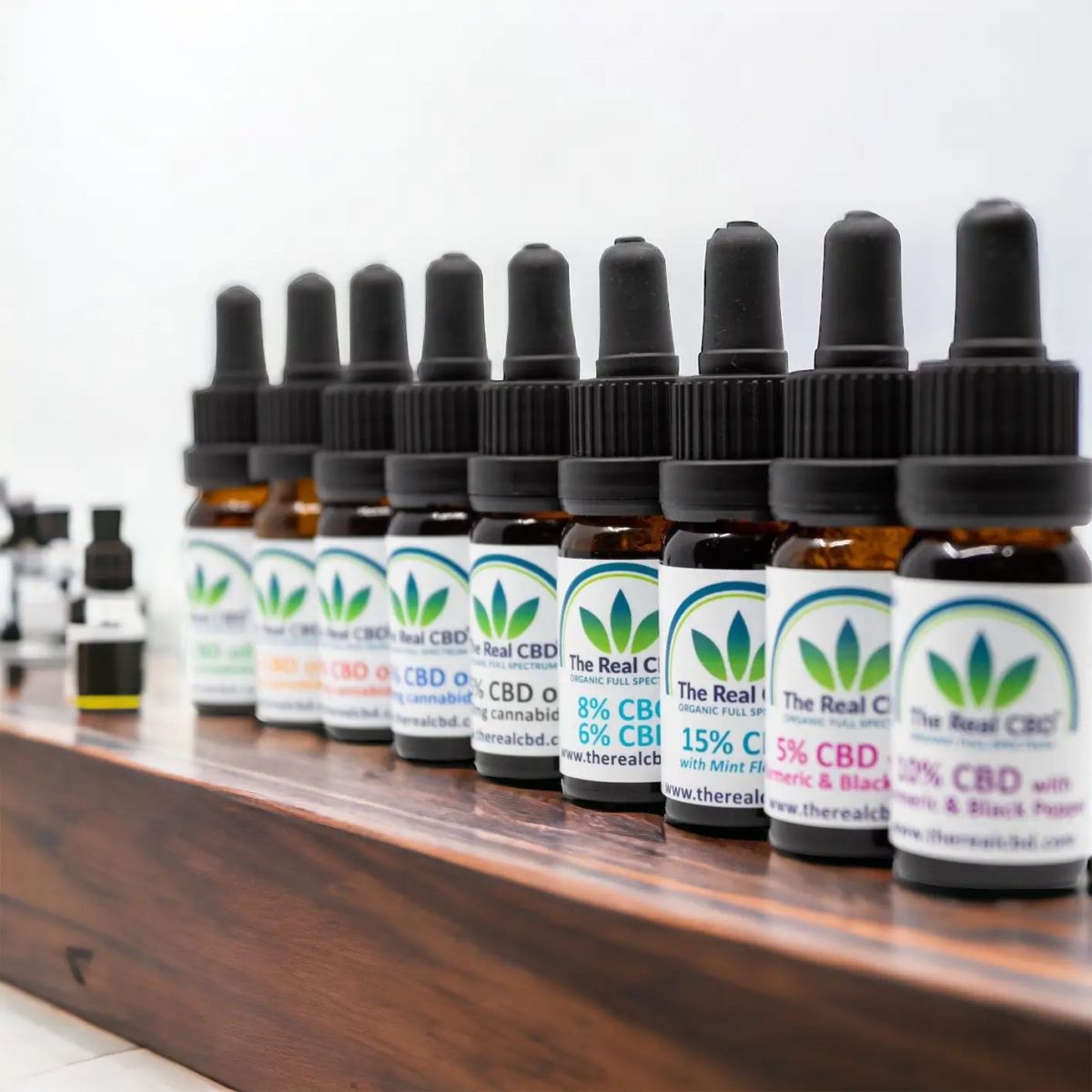 Línea de tinturas de CBD sobre mesa de madera - The Real CBD Marca