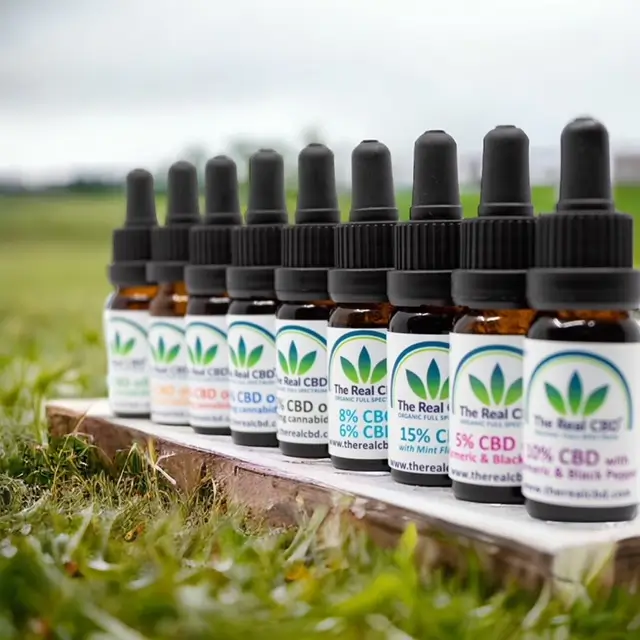 Línea de tinturas de CBD en un campo - The Real CBD Marca