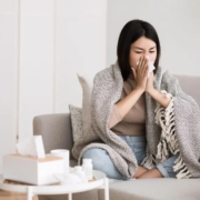 The-Real-CBD-Blog-CBD para el resfriado común y la gripe Mujer resfriada en un sofá sonándose la nariz