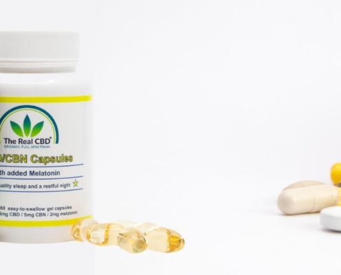 Los productos Real CBD y el vaso de pastillas inclinado sobre la mesa