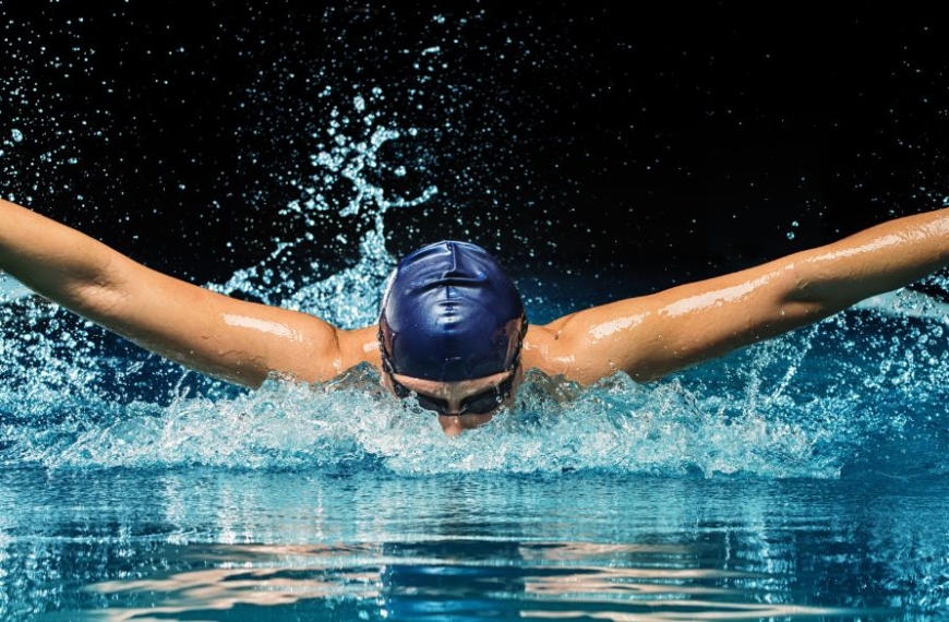 Nadador haciendo mariposa en una piscina
