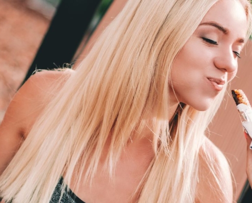 Mujer rubia comiendo con avidez