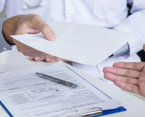 Un médico entrega una receta a un paciente