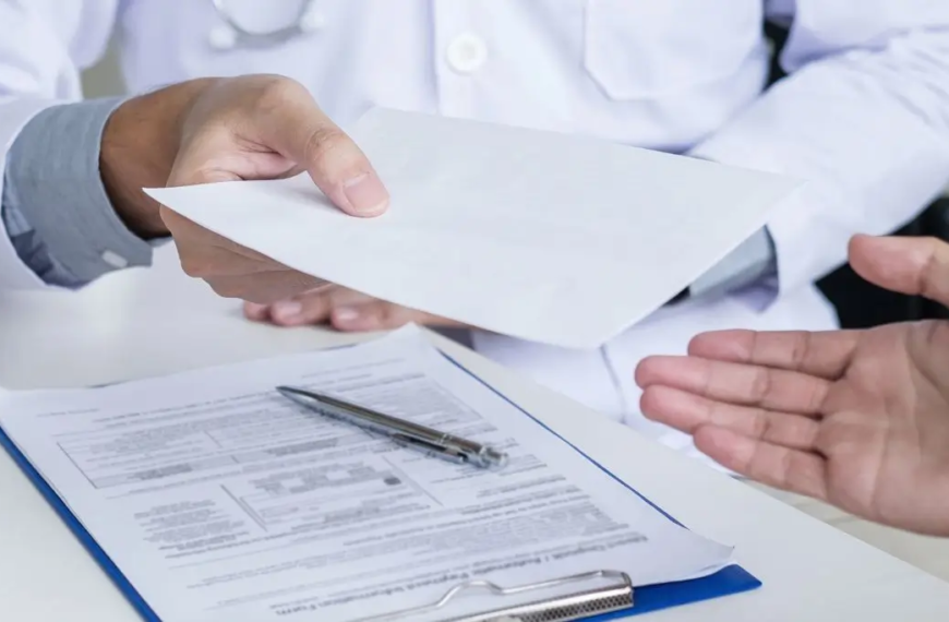 Un médico entrega una receta a un paciente