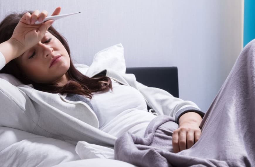 Mujer en cama con fiebre alta
