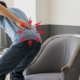 Hombre agachado con dolor sujetándose la espalda