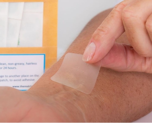 Persona colocándose un parche contra el dolor de CBD en el brazo