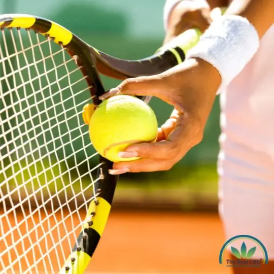 Pelota de tenis sostenida por raqueta al sol