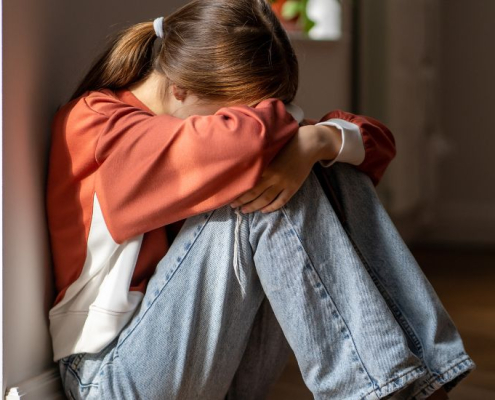 María sentada en el suelo mientras sufre un ataque de ansiedad