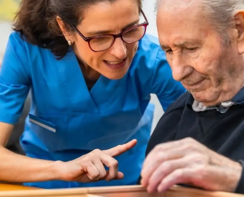 Mujer ayudando a un anciano con un juego de memoria