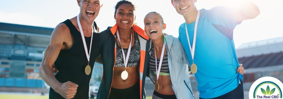 4 atletas con medallas colgadas del cuello con cara de felicidad