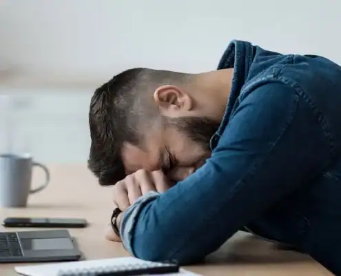 Hombre durmiendo en una mesa de oficina