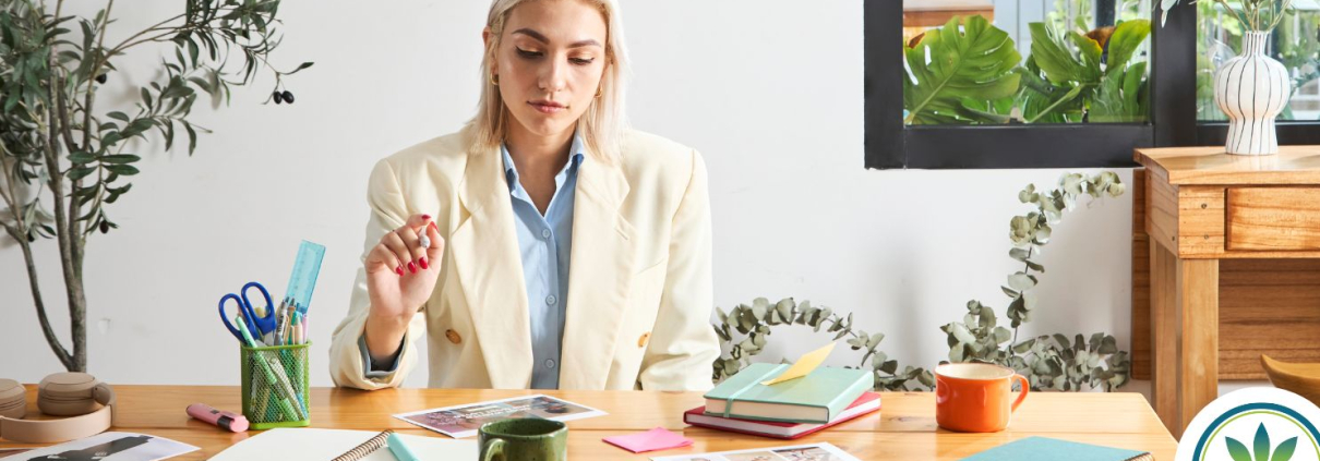 Mujer trabajando junto a un escritorio repleto.