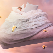 the-real-cbd-blog-cbd-para-sueños-lúcidos Mujer durmiendo en una cama grande que vuela por el cielo.