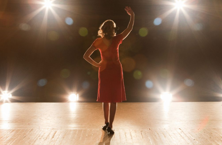 Mujer en el escenario vista desde atrás