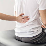 the-real-cbd-blog-CBD-para-el-alivio-del-dolor-crónico-de-la-articulación-sacroilíaca Un terapeuta sujetando la zona lumbar de un paciente, preparándose para el tratamiento.