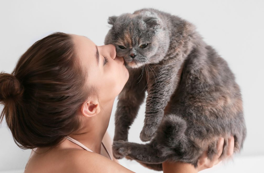 Mujer besando a su gato