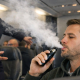 Una azafata impide a un hombre usar un cigarrillo electrónico en un avión.