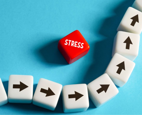 Dados rojos con la palabra «STRESS» sobre una fila de dados blancos con flechas negras apuntando hacia arriba