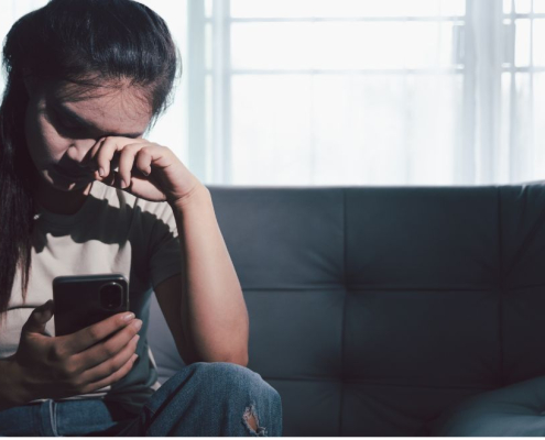 Una mujer sentada en un sofá que parece estar abrumada emocionalmente