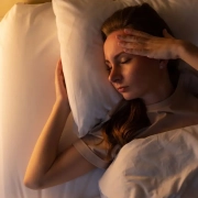 the-real-cbd-blog-Cómo-puede-afectar-CBD-a-la-latencia-del-sueño-en-adultos Una mujer tumbada en la cama intentando dormir