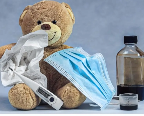 Jarabe para la tos y aceite de CBD junto con un osito de peluche