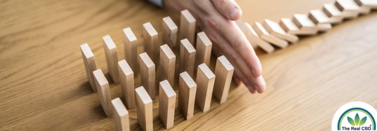 Houten stenen met de hand tegenhouden zodat ze niet als dominostenen naar beneden vallen