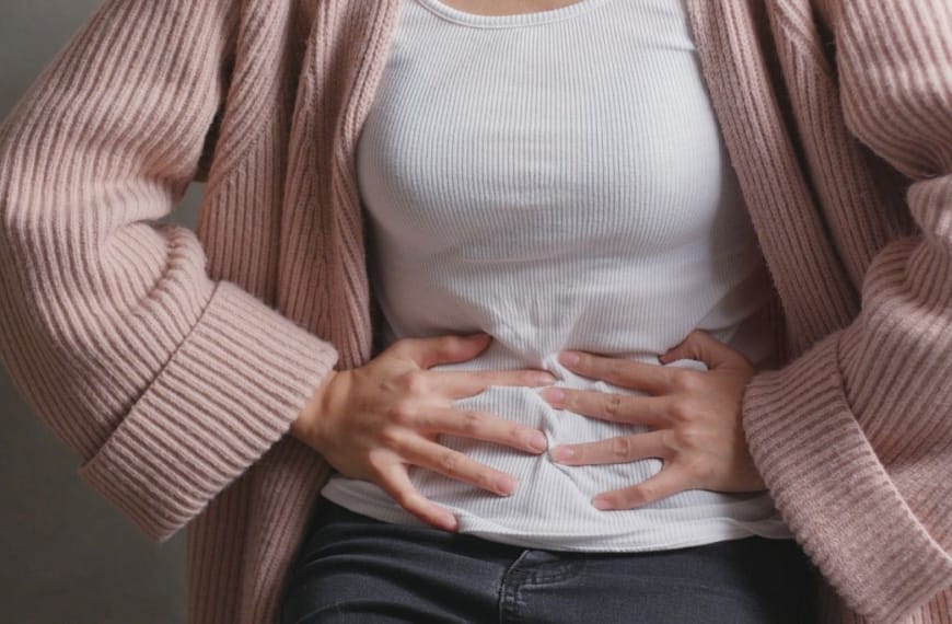 Frau hält sich den Bauch