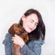 Zuneigung-Tier-Brünette Frau hält einen Hund, der ihr Gesicht leckt