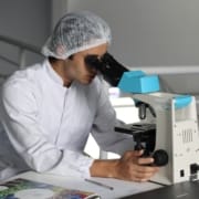 CBD-Forschung Wissenschaftlerin schaut in ein Mikroskop