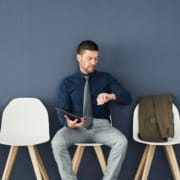 The-Real-CBD-Blog-Wie-lange-bleibt-CBD-im-Körper Mann schaut in einem Wartezimmer auf seine Uhr